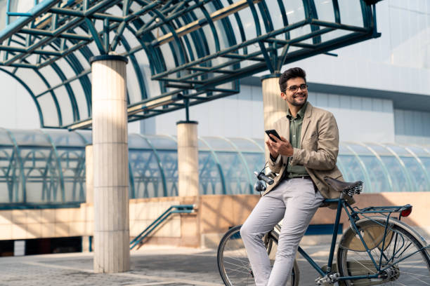 istock Smiling Businessman with Bicycle Using Smartphone Outdoors 2171953910