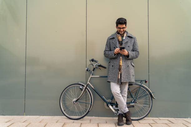 istock Businessman Checking Phone with Bike 2171954009