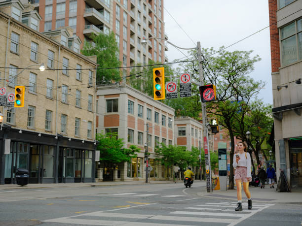 Woman using smartphone on crosswalk in Toronto