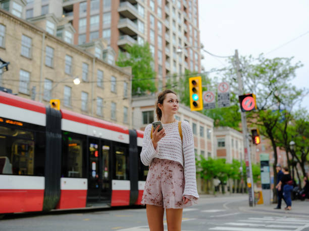 Woman using smartphone on crosswalk in Toronto