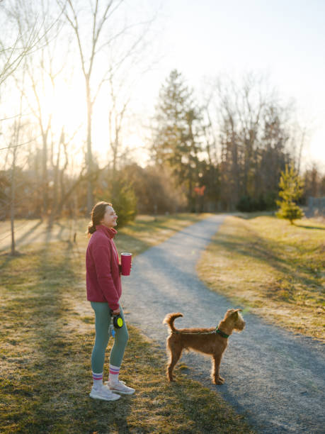istock Woman on walk with dog in springtime at sunset 2171954650