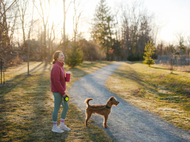 istock Woman on walk with dog in springtime at sunset 2171954652