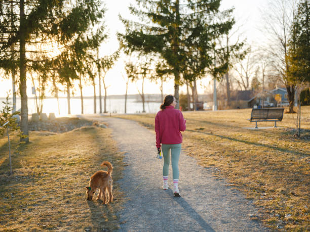 istock Woman on walk with dog in springtime at sunset 2171954716