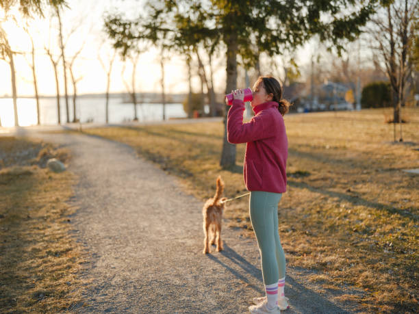 istock Woman on walk with dog in springtime at sunset 2171954740