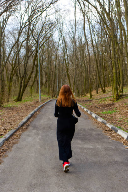 istock A solitary woman walks along a serene forest path 2171957553