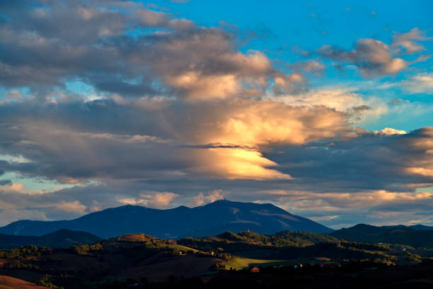 Autumn hill panorama against cloudy sky in golden hour in Montefeltro