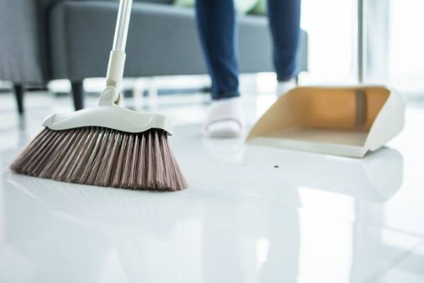 istock A woman sweeping the floor with a broom and dustpan 2171967551