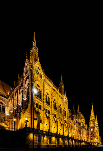 The illuminated Hungarian Parliament Building reflects beautifully in the Danube River, showcasing its stunning neo-Gothic architecture.
