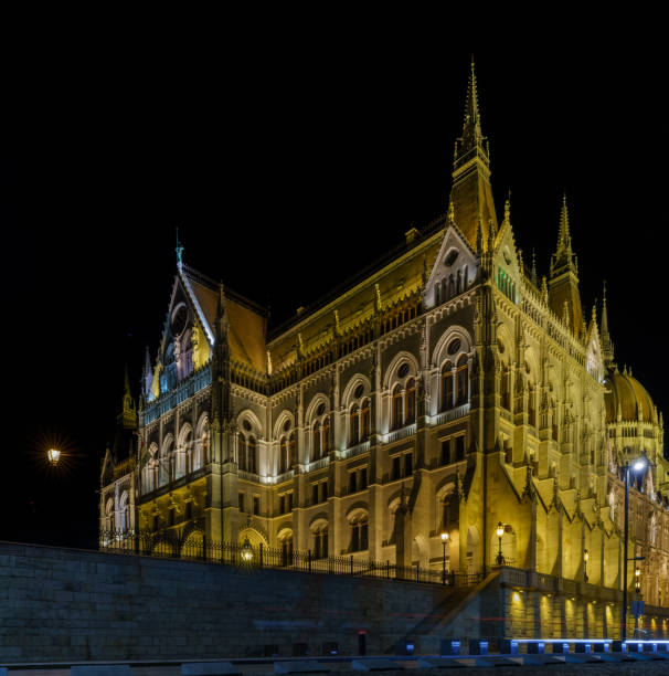 The illuminated Hungarian Parliament Building reflects beautifully in the Danube River, showcasing its stunning neo-Gothic architecture.