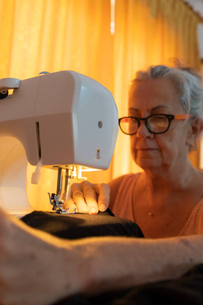 istock Elderly woman concentrating on sewing with a sewing machine. 2171972093