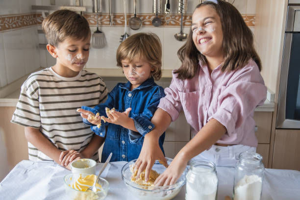 istock Three Children Are Baking Together In The Kitchen, Mixing Dough And Laughing While Covered In Flour. 2171974315