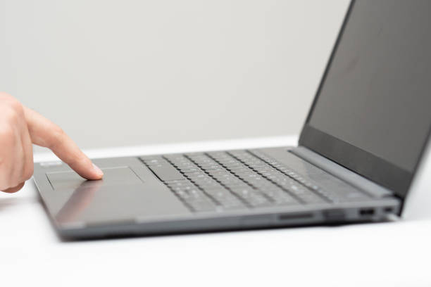 Male finger touching laptop touchpad