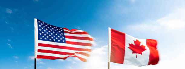 istock USA and Canada flags against blue sky background 2171977737