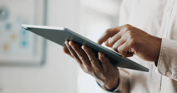 istock Close-up of a Businessman Typing on Digital Tablet in Office Setting 2171977829