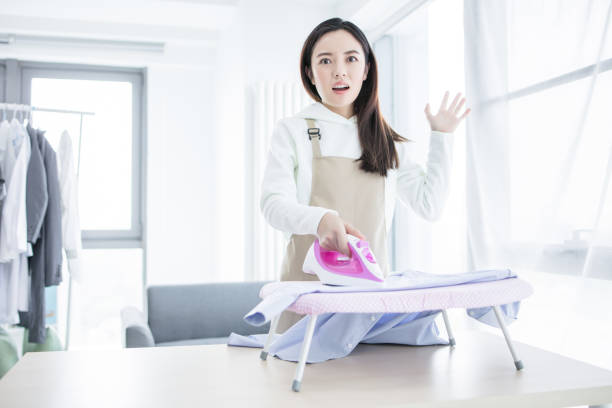 Happy young beautiful woman ironing clothes. Housework