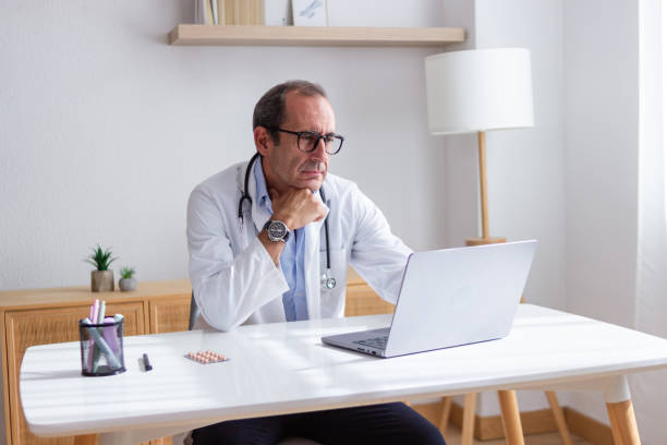 istock Serious doctor analyzing medical report on laptop in office 2171979909