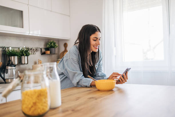 istock A young cheerful woman eating cornflakes for breakfast in the kitchen. 2171981828