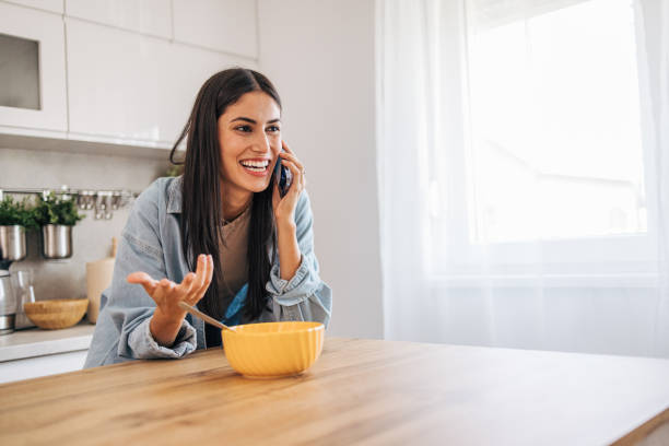 istock A young cheerful woman eating cornflakes for breakfast in the kitchen. 2171981839
