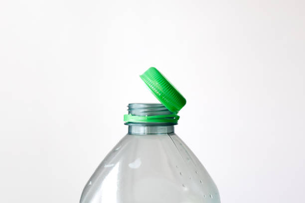 Open plastic bottle with green cap, close-up on white background