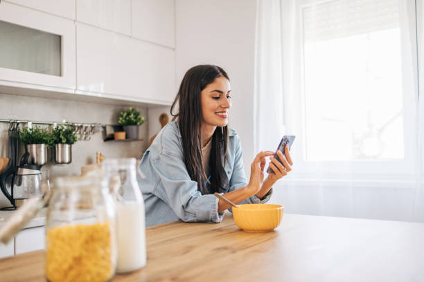istock A young cheerful woman eating cornflakes for breakfast in the kitchen. 2171982124