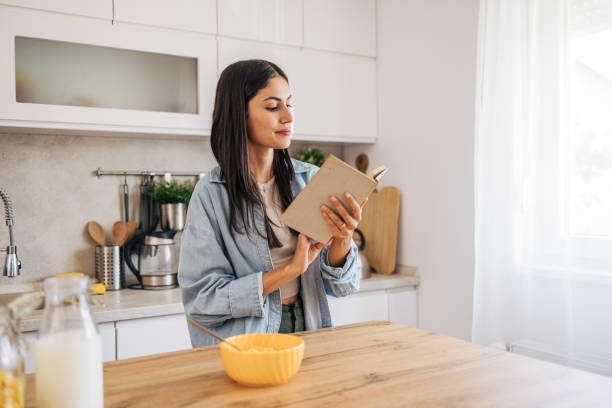 istock A young cheerful woman eating cornflakes for breakfast in the kitchen. 2171983843