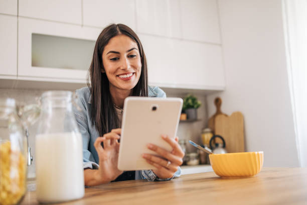 istock A young cheerful woman eating cornflakes for breakfast in the kitchen. 2171985554
