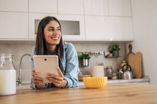 istock A young cheerful woman eating cornflakes for breakfast in the kitchen. 2171985557