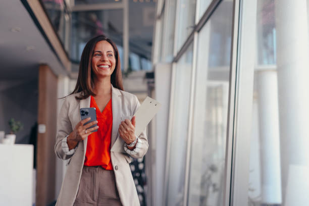 istock Smiling businesswoman using phone in office 2171991913