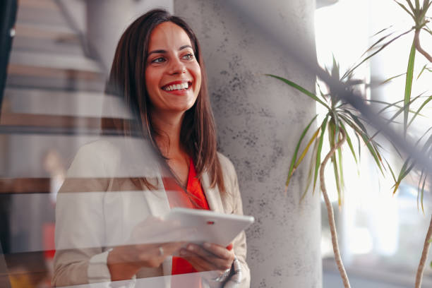 istock Smiling businesswoman in modern office holding tablet 2171991976