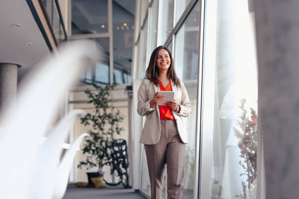 istock Smiling businesswoman in modern office holding tablet 2171991982