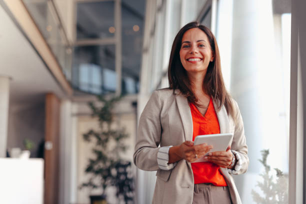 istock Smiling businesswoman in modern office holding tablet 2171991990