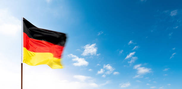 istock German flag waving against blue sky background 2171992063