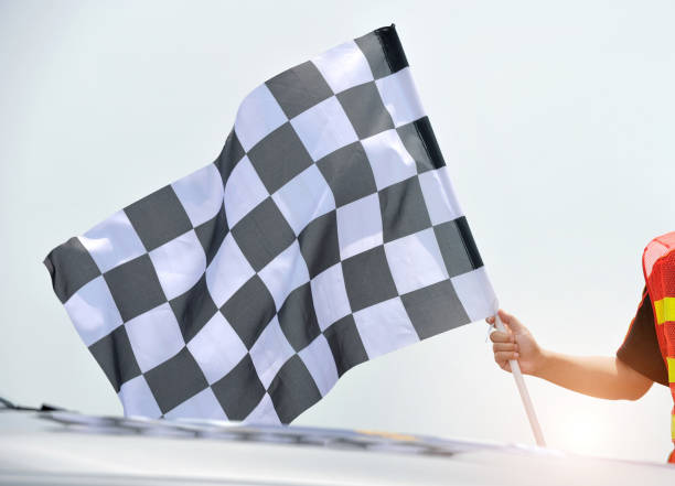 istock Checkered race flag in hand against white background 2171992586