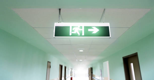 istock Exit sign suspended from the ceiling of hospital corridor 2171992794