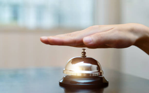 istock Female hand ringing in service bell on wooden table 2171992856