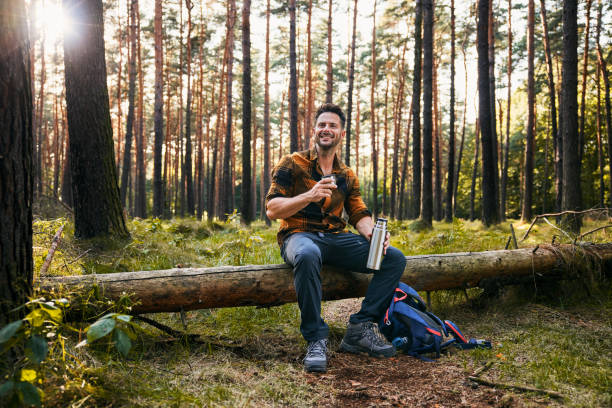 istock Adult man resting in forest during autumn hike drinking from thermos 2171993780