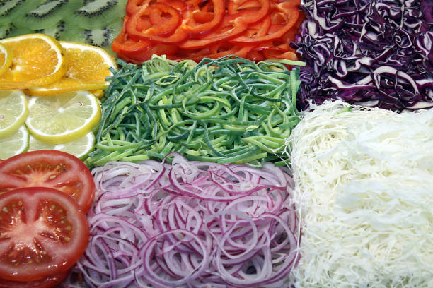 various fruits and vegetables, decorated on a serving platter with kiwi, orange, lemon, tomatoes, red onions, red cabbage, peppers, celery, leek,
