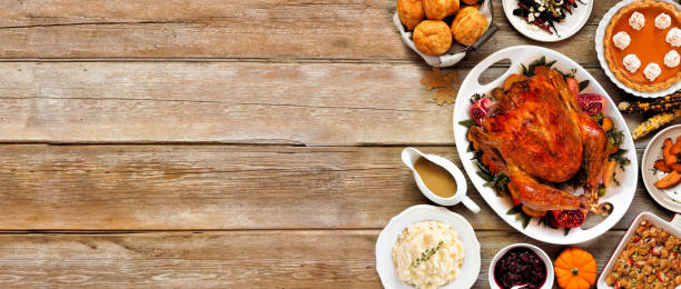 istock Thanksgiving turkey dinner. Above view side border on a rustic wood table banner background. 2171995733