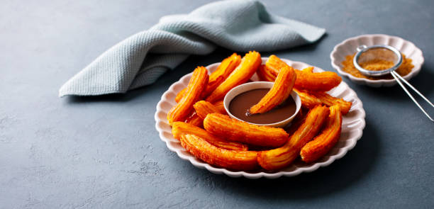 istock Churros dessert with chocolate sauce, dip, topping on plate. Gray background. Copy space. 2171997051