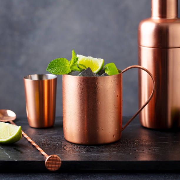 istock Cocktail Moscow mule in copper mug, shaker with mint leaf and lime. Dark background. Close up. 2171997326