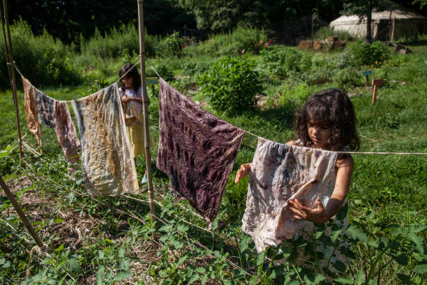 istock Two young girls hang dyed fabric on clothesline 2172004600