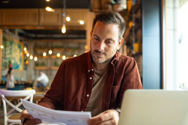 istock Man reading papers thoughtfully in a cozy cafe. 2172005796