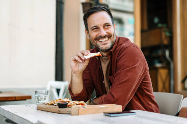 Man smiling while enjoying delicious snack at cafe.