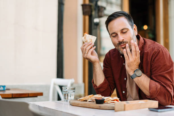 istock Man savoring flavorful quesadilla at cozy eating spot. 2172005865