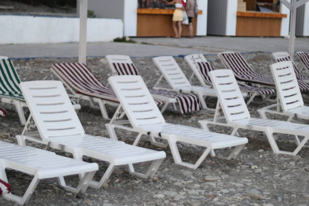 Row of lawn chairs on a gravel surface.