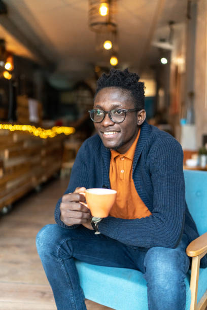 istock Young black man sitting in cafe and drinking coffee 2172013815