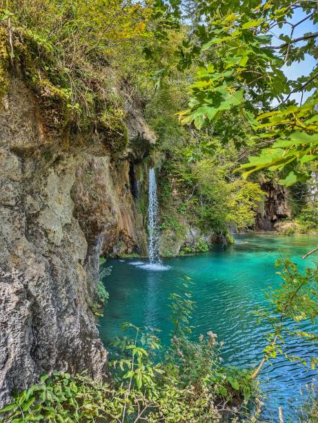 istock A serene waterfall cascades into a turquoise pool surrounded by lush greenery at Plitvice Lakes National Park, Croatia 2172018981