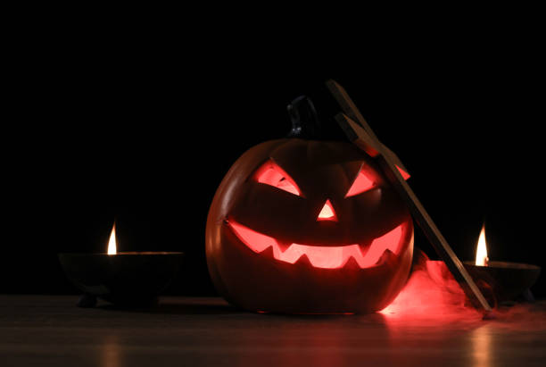 Spooky Halloween pumpkins, Halloween Jack-o-Lantern Pumpkins, Jack O Lantern with evil faces and eyes isolated against a dark background.