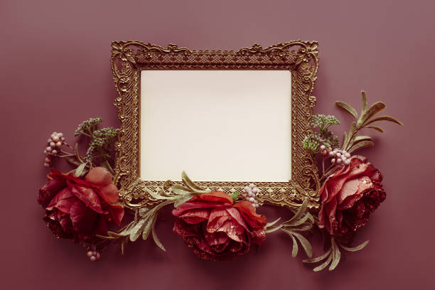 Vintage openwork bronze metal frame on a red pink background decorated with flowers, empty picture frame mockup