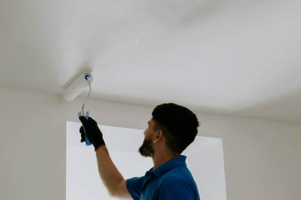 istock A young oriental man paints the ceiling with a roller. 2172026204
